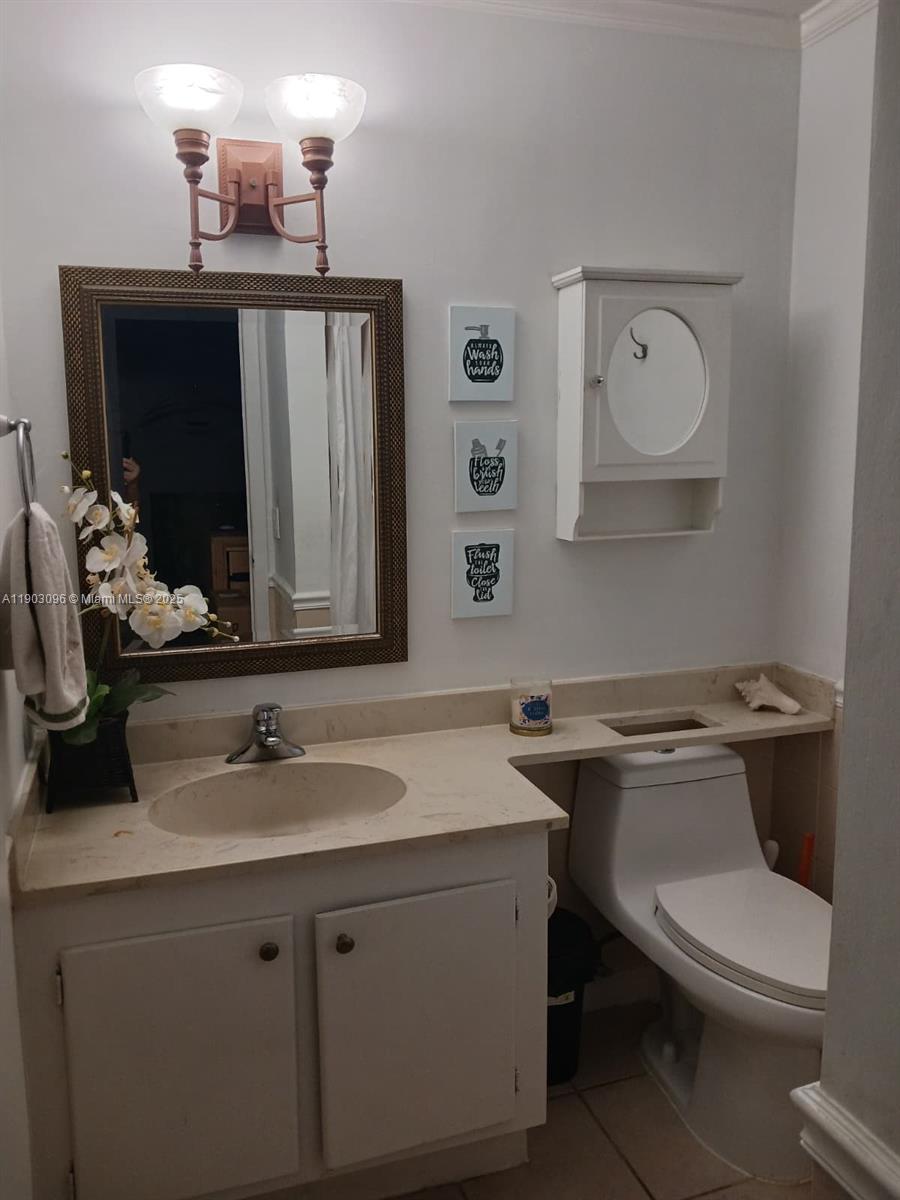8340 Southwest 154th Avenue, Unit 63 Miami, FL 33193 - Photo 6 of 18 a bathroom with a toilet sink and mirror