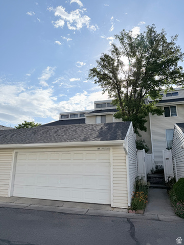 227 South West Lane Provo, UT 84601 - Photo 3 of 25 Double-car garage with a paneled white door, asphalt driveway, and light-colored siding