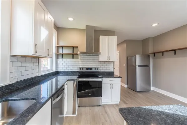 a kitchen with granite countertop white cabinets and a sink