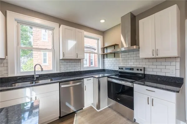 a view of a kitchen with a refrigerator and a sink