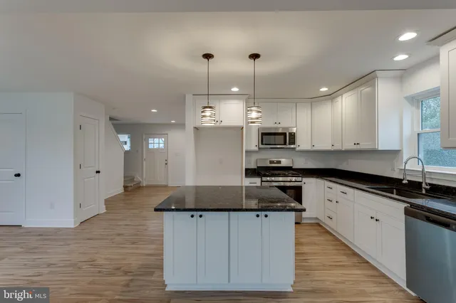 a large kitchen with stainless steel appliances granite countertop a stove a sink and a granite counter tops