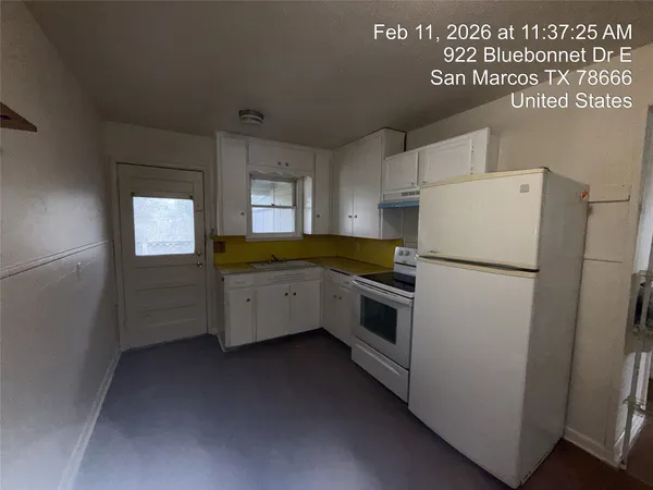 a kitchen with a refrigerator a stove top oven and cabinets