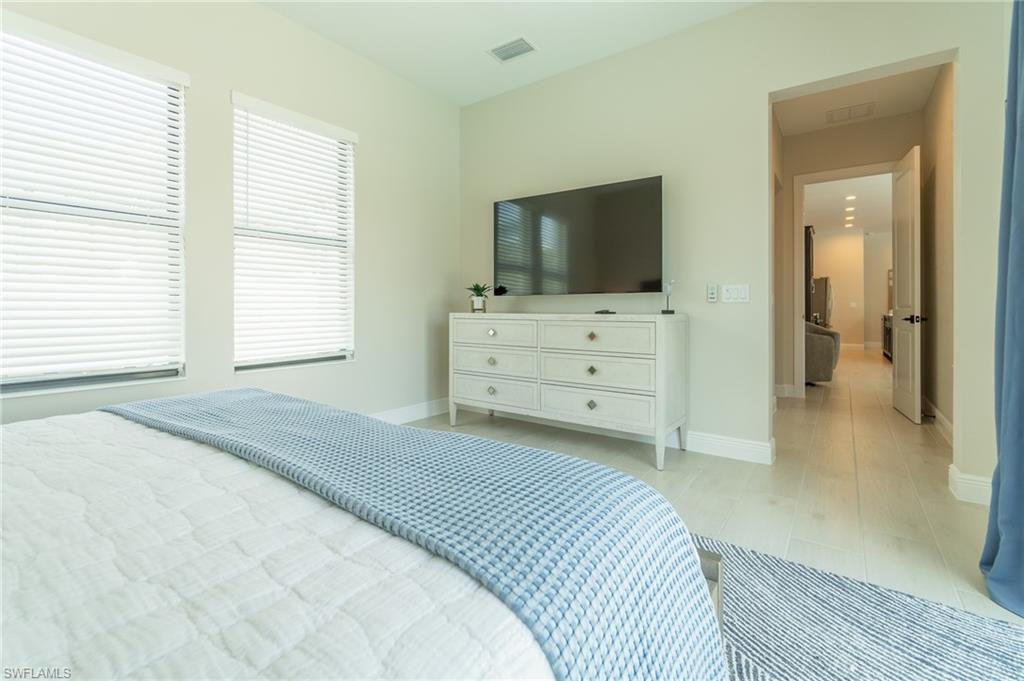 822 105th Avenue North Naples, FL 34108 - Photo 13 of 30 a bedroom with a bed and a flat screen tv