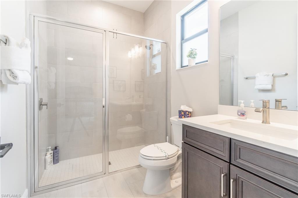822 105th Avenue North Naples, FL 34108 - Photo 18 of 30 a bathroom with a shower sink vanity mirror and toilet