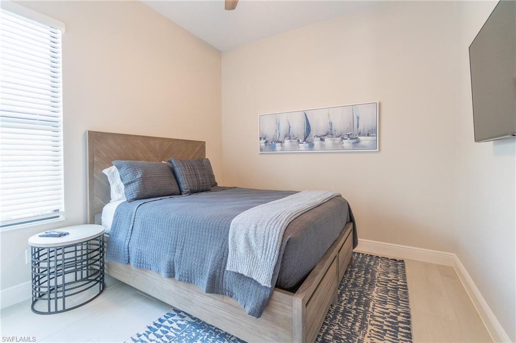 822 105th Avenue North Naples, FL 34108 - Photo 19 of 30 a bedroom with a bed and painting on the wall