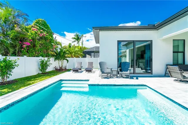 a view of a house with swimming pool and sitting area