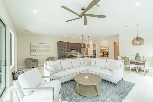 a living room with furniture and a view of kitchen