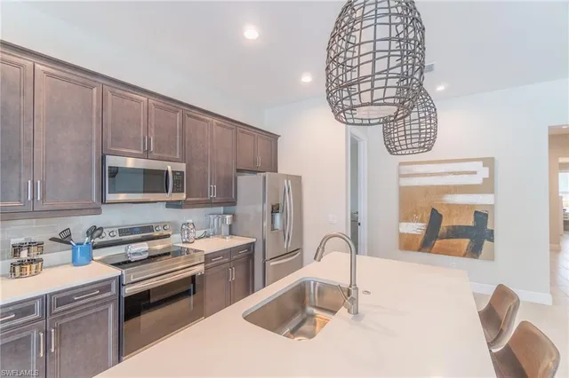 a kitchen with stainless steel appliances a sink dishwasher a stove a microwave oven with cabinets and wooden floor