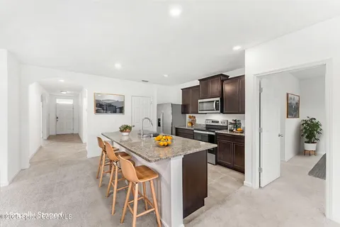 a kitchen with stainless steel appliances granite countertop a refrigerator and a stove top oven