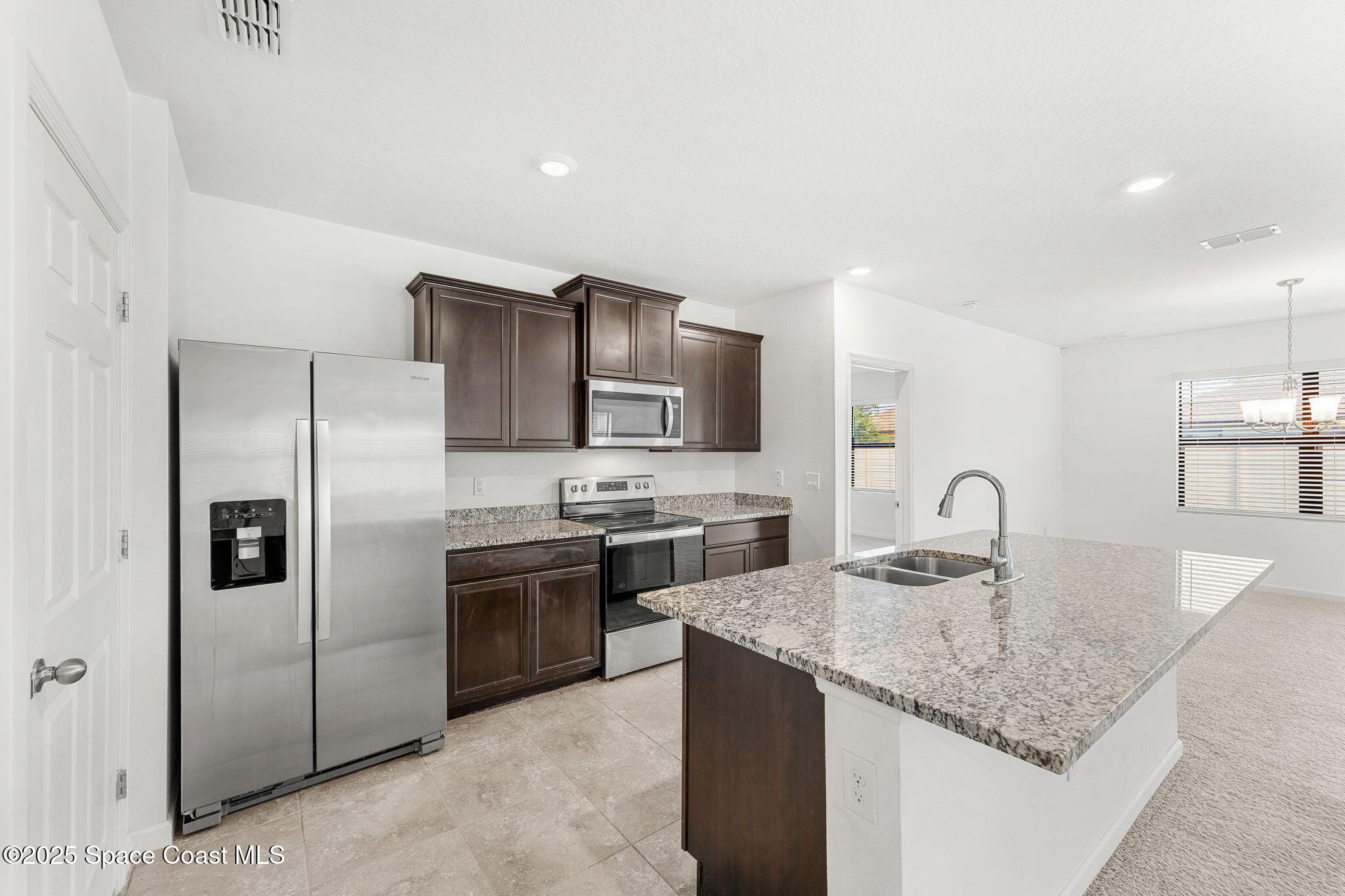 4667 Magenta Isles Drive Melbourne, FL 32904 - Photo 5 of 29 a kitchen with stainless steel appliances granite countertop a sink a stove and refrigerator