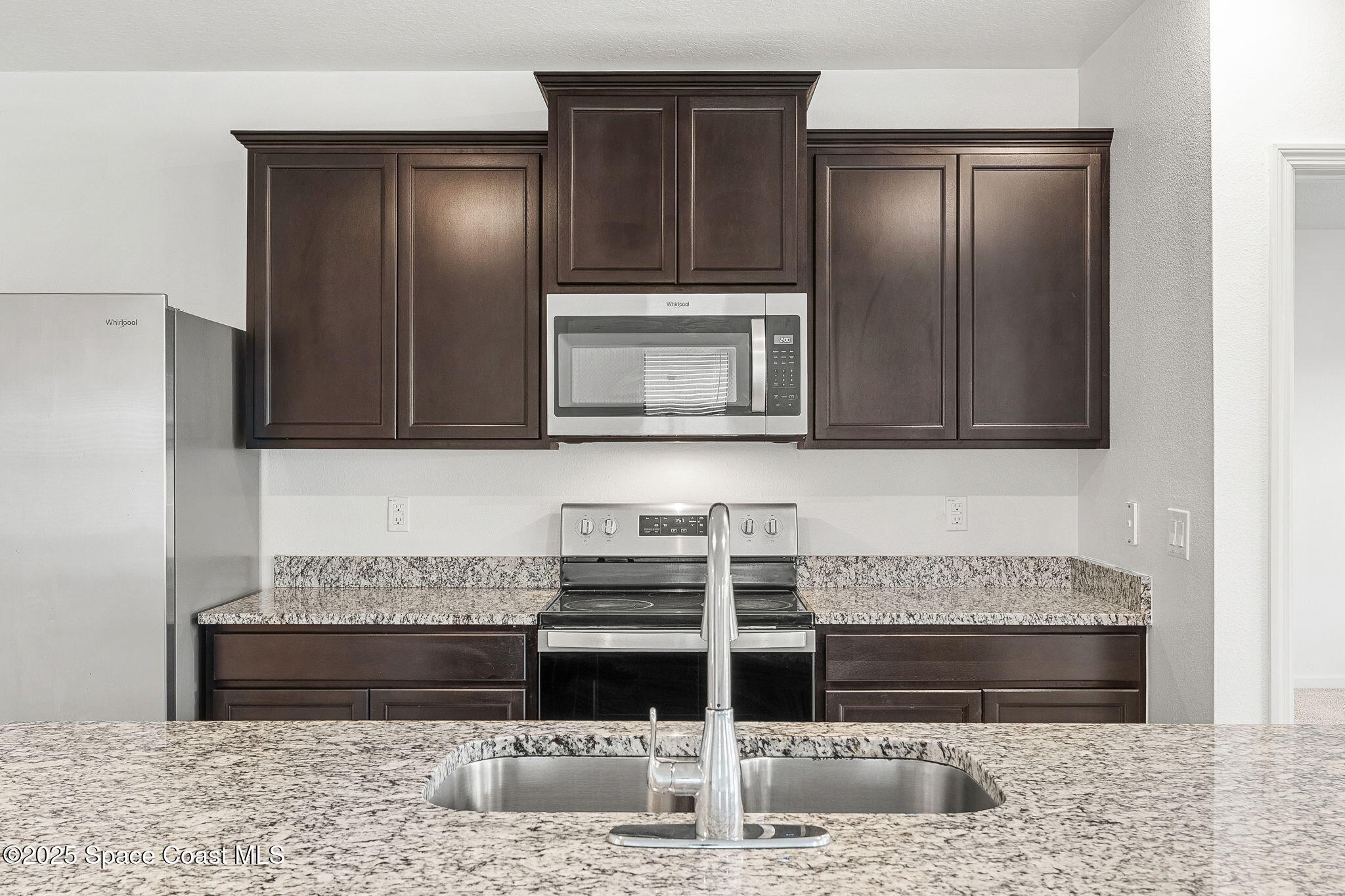 4667 Magenta Isles Drive Melbourne, FL 32904 - Photo 6 of 29 a kitchen with granite countertop a stove and cabinets