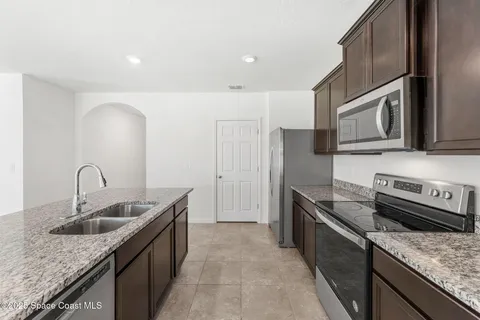 a kitchen with stainless steel appliances granite countertop a sink stove and cabinets