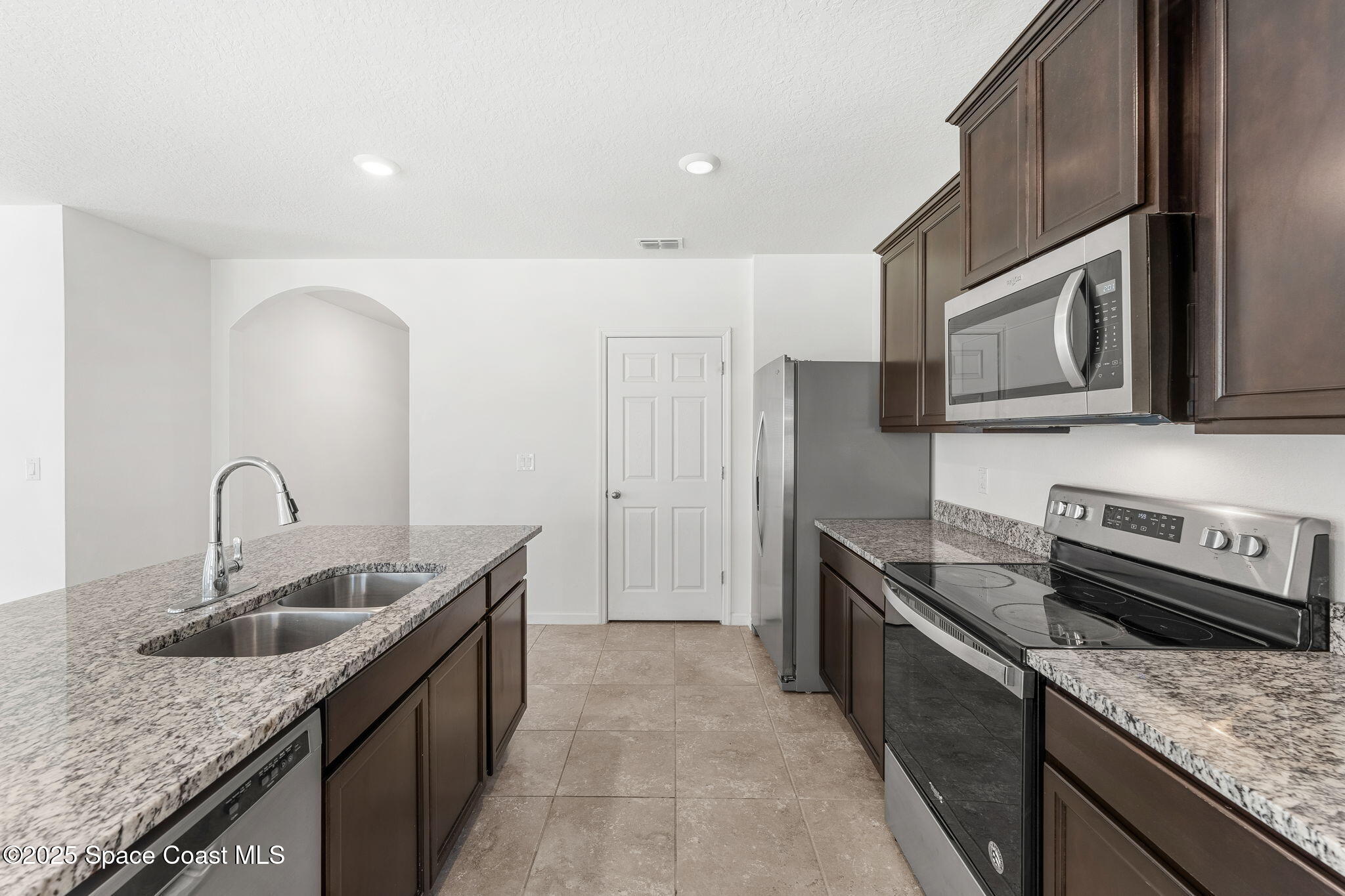 4667 Magenta Isles Drive Melbourne, FL 32904 - Photo 8 of 29 a kitchen with stainless steel appliances granite countertop a sink stove and cabinets