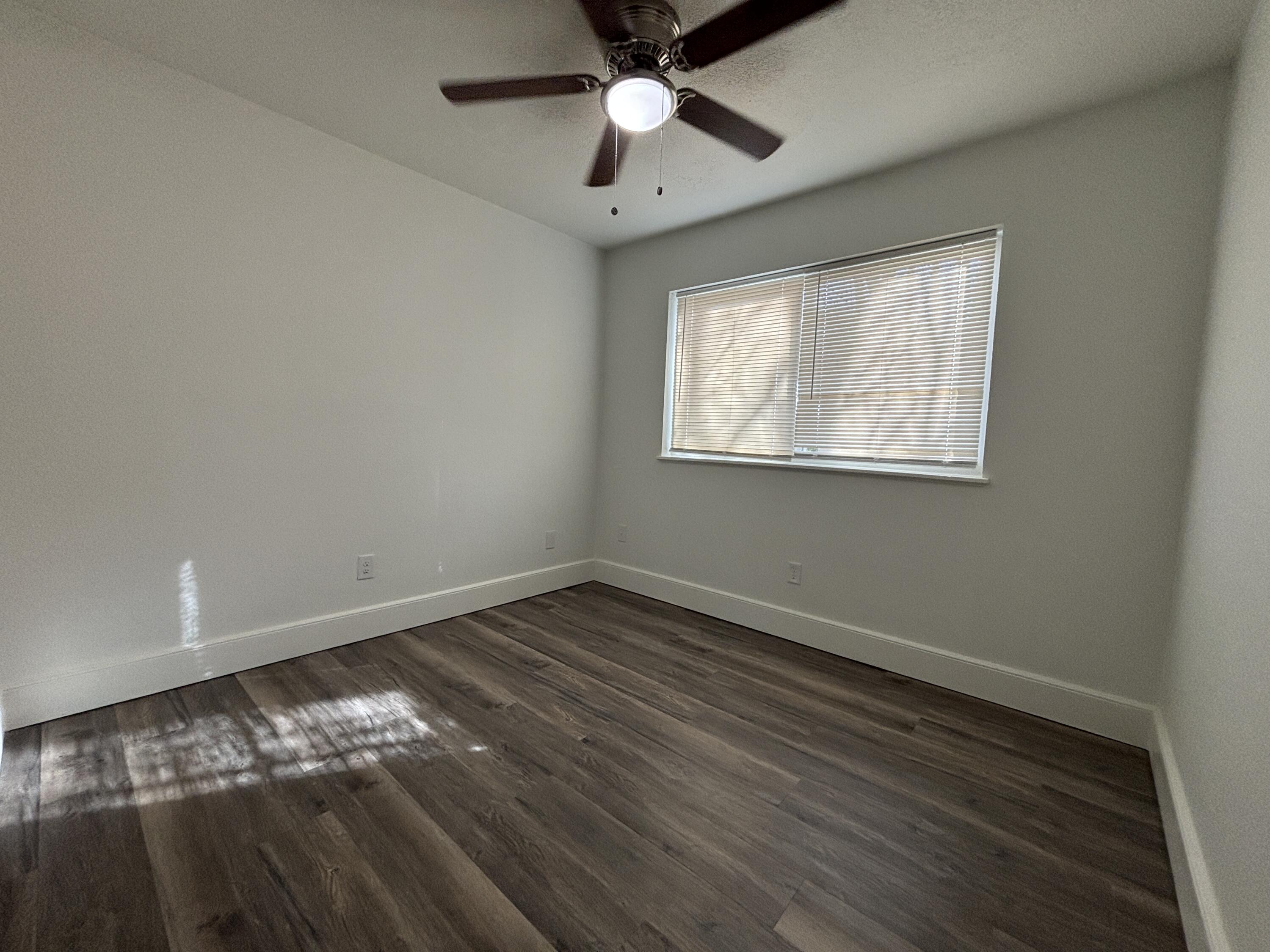 7406 Globe Avenue Lubbock, TX 79404 - Photo 8 of 10 a view of an empty room with wooden floor and a window