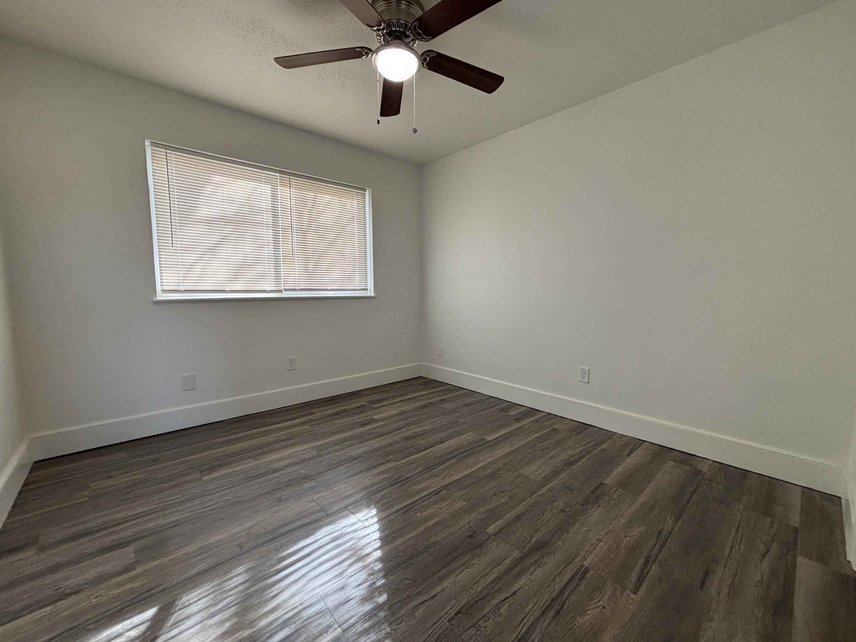 7406 Globe Avenue Lubbock, TX 79404 - Photo 9 of 10 a view of an empty room with wooden floor and a window