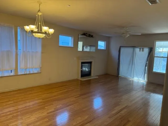 a view of a livingroom with wooden floor and a chandelier