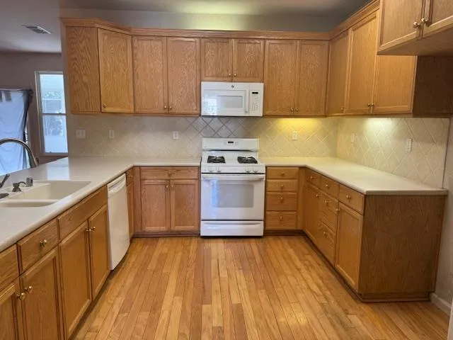 a kitchen with wooden floors and wooden cabinets