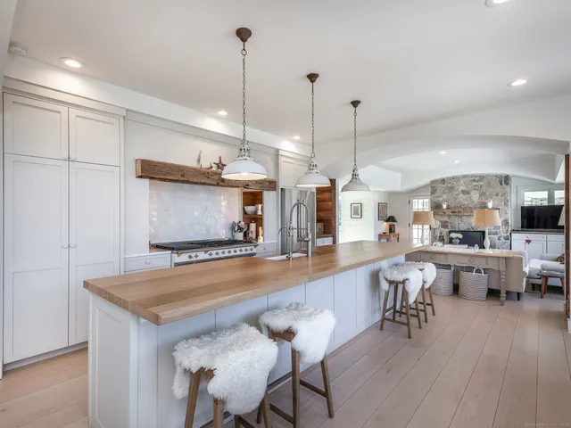 a view of a dining room and livingroom with furniture wooden floor a chandelier
