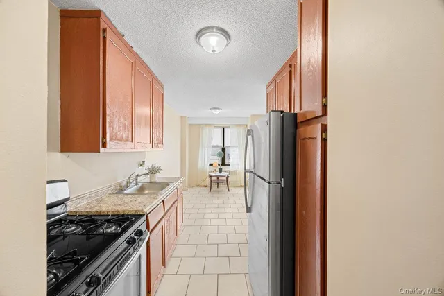a kitchen with granite countertop a stove and a refrigerator