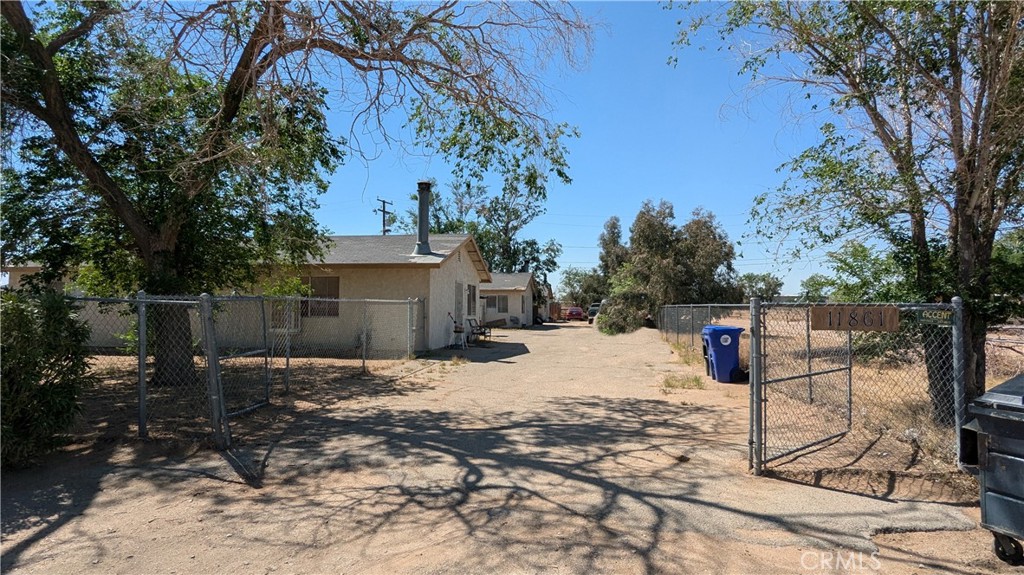 a backyard of a house with barbeque oven and trees