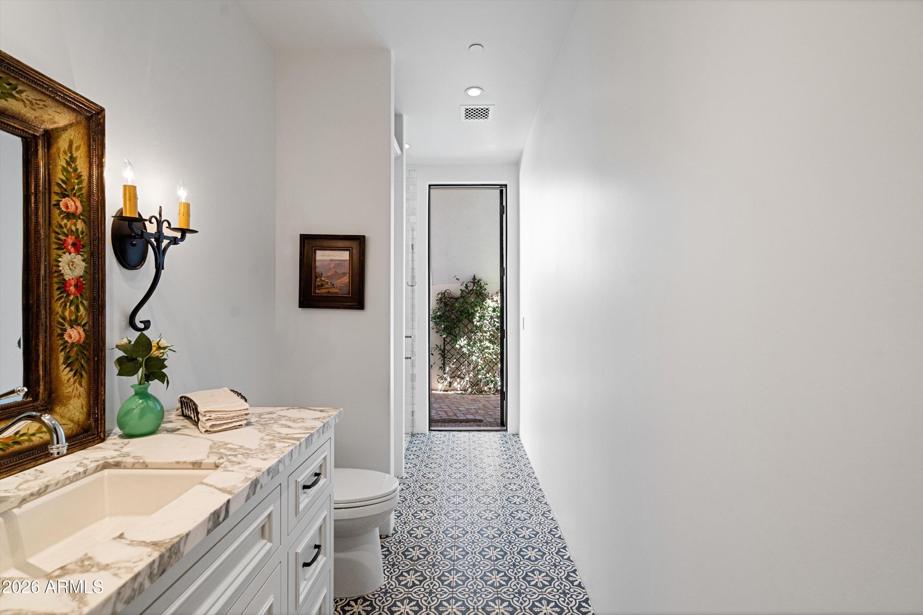 5434 East Camel Hill Road Phoenix, AZ 85018 - Photo 63 of 147 a bathroom with a granite countertop sink a toilet and mirror