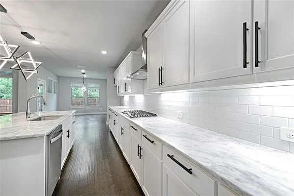 a large kitchen with granite countertop a sink stainless steel appliances and cabinets