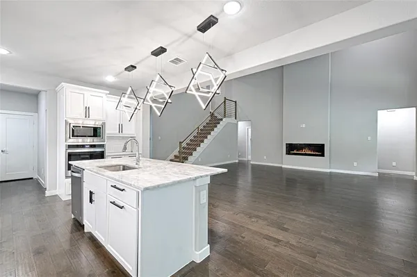 a view of a kitchen with sink and wooden floor
