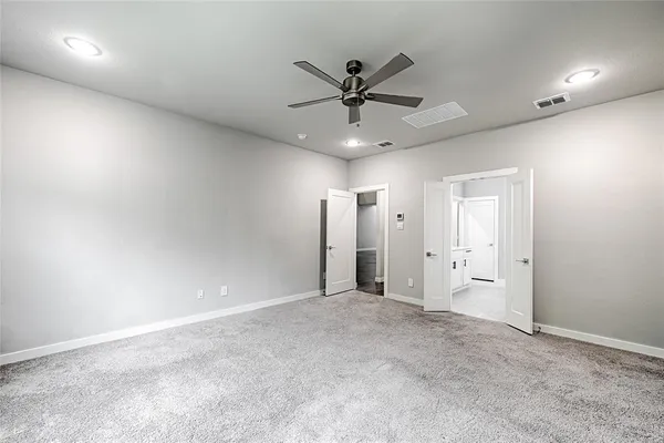 an empty room with closet and a ceiling fan