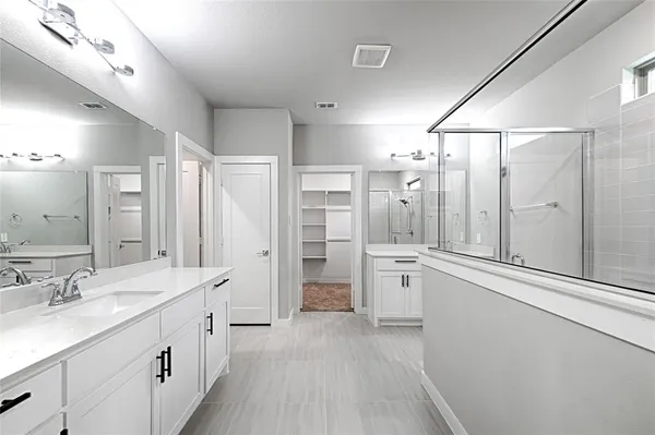 a large bathroom with a granite countertop double vanity sink a large mirror a shower and bathtub