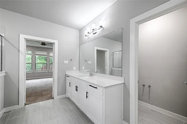 a spacious bathroom with a double vanity sink and a mirror