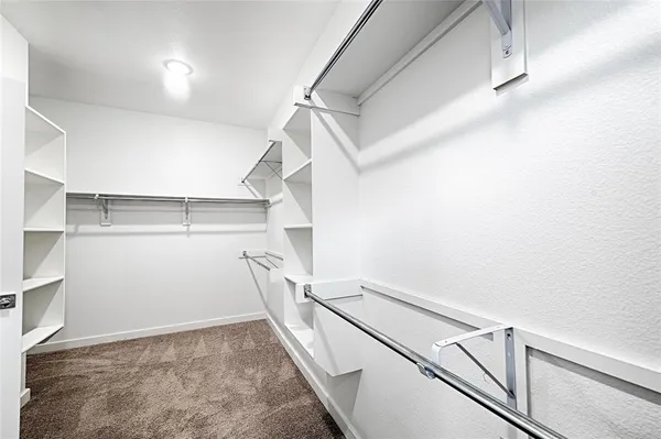 a view of walk in closet with empty racks