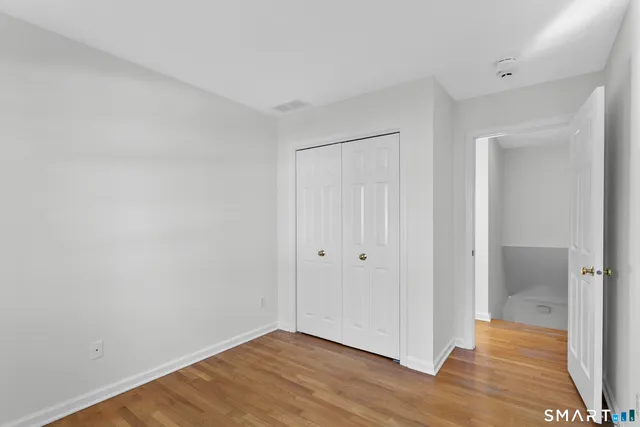 a view of an empty room with wooden floor