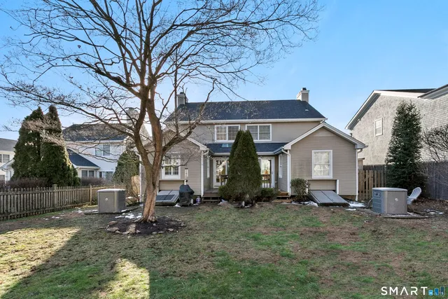 a view of a house with backyard and a tree