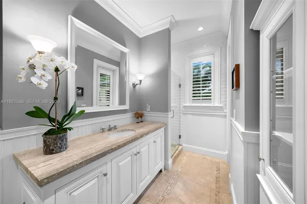 a bathroom with a granite countertop sink a large mirror and a shower