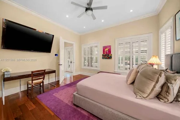 a bedroom with a bed a flat screen tv and a large window