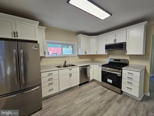 a kitchen with granite countertop white cabinets and stainless steel appliances