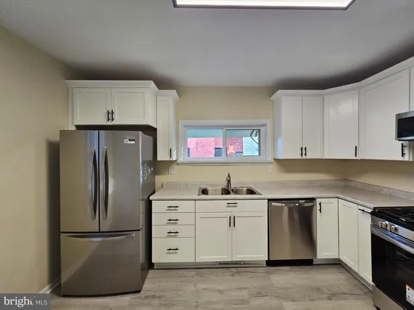 a kitchen with a refrigerator sink and cabinets