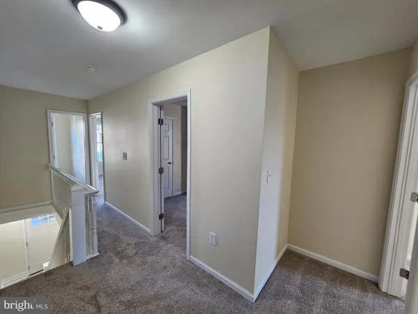 a view of a hallway with wooden floor and entryway