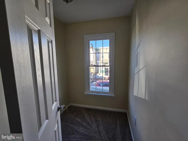 an empty room with windows and ceiling fan
