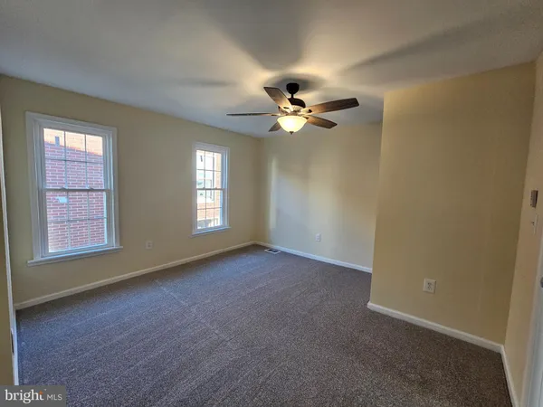 an empty room with closet and a chandelier fan