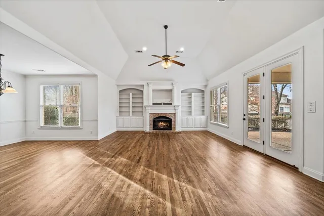 a view of an empty room with a fireplace and a window
