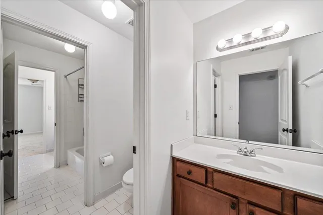 a bathroom with a granite countertop sink mirror and a toilet