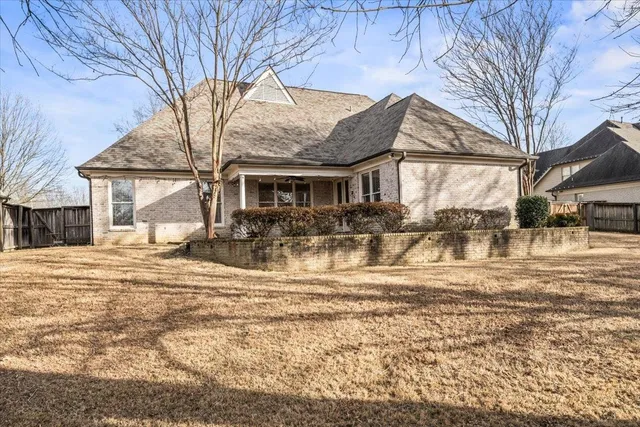 a view of a white house with a large tree and a yard