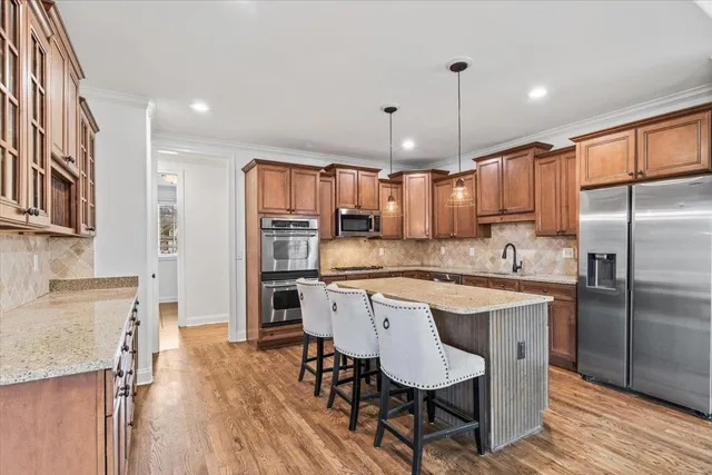 a kitchen with refrigerator a sink and chairs