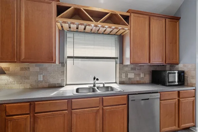 a kitchen with stainless steel appliances granite countertop a sink a microwave cabinets and a wooden floor