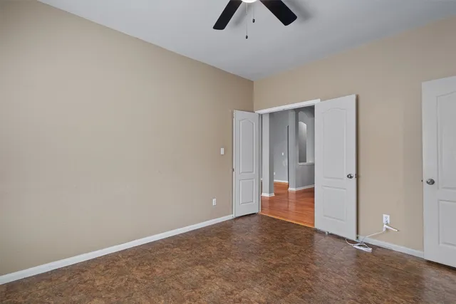an empty room with an entryway and chandelier