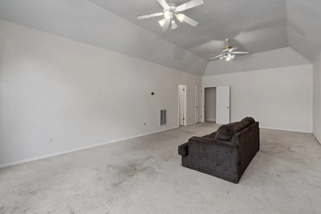 a living room with furniture and a ceiling fan
