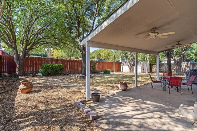 a view of a patio with a table chairs and a backyard