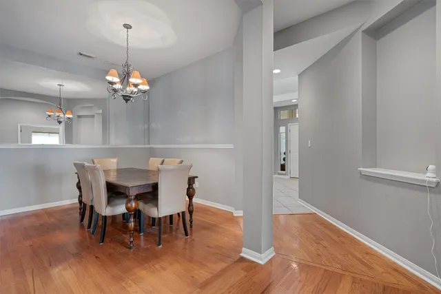 a view of a dining room with furniture wooden floor and chandelier