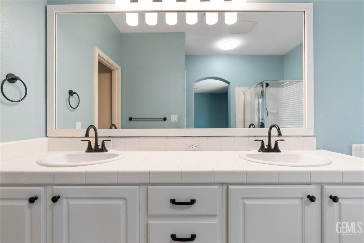Undisclosed Address Bakersfield, CA 93312 - Photo 14 of 45 a bathroom with a sink and a mirror